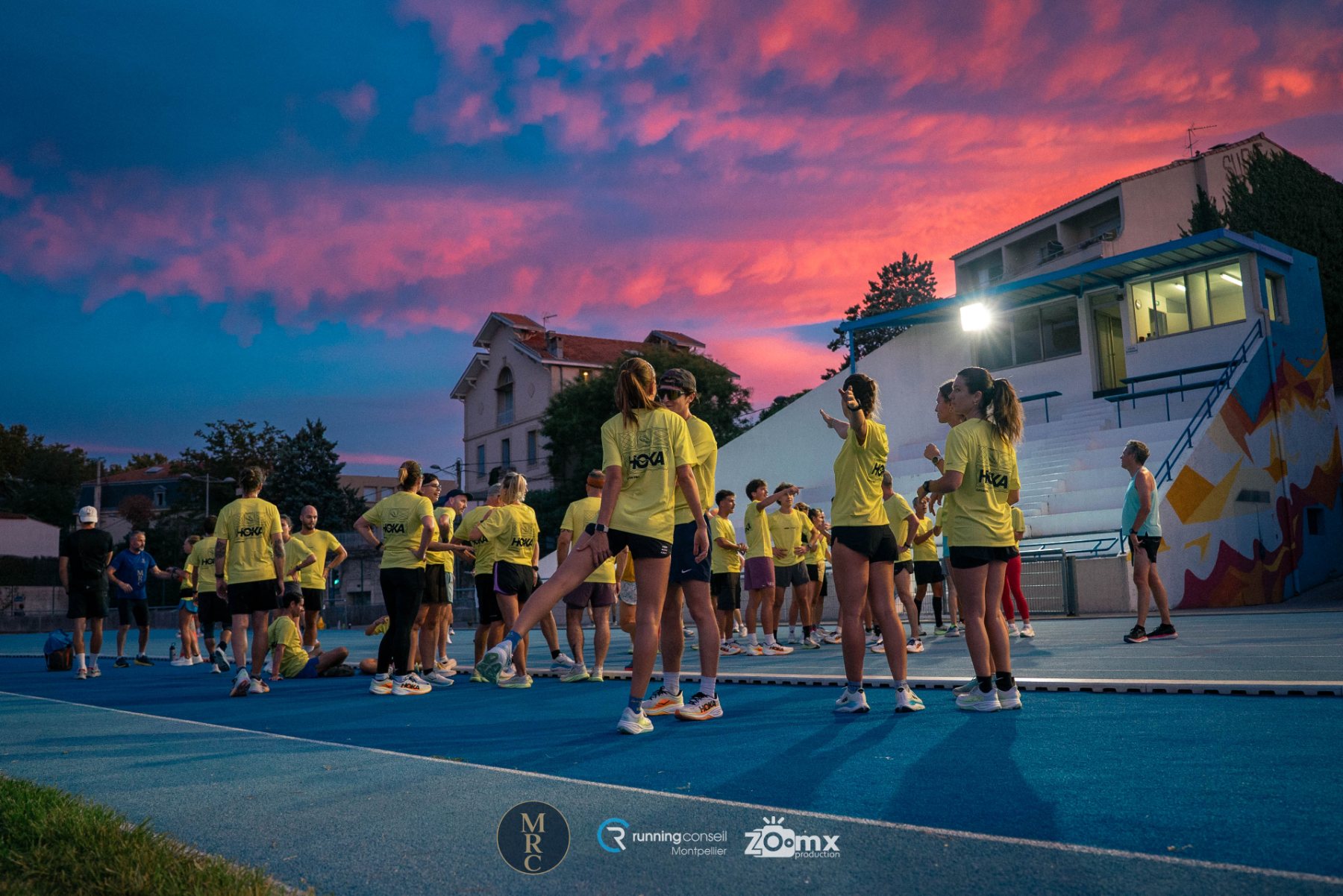 Groupe de coureurs sur la piste sous un ciel rose